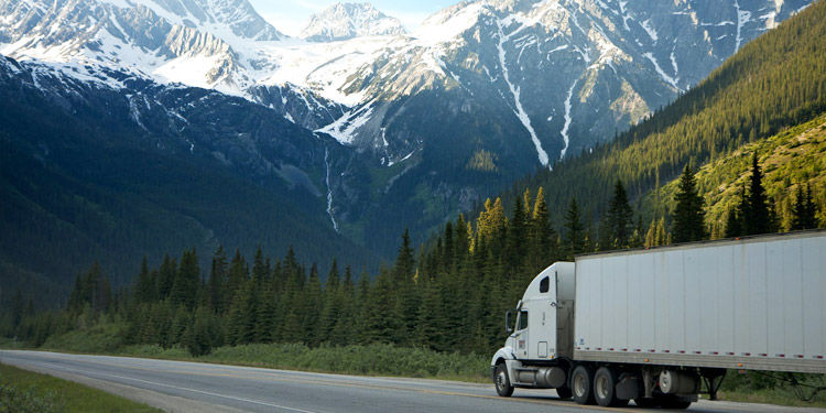 semi truck driving into mountainous region